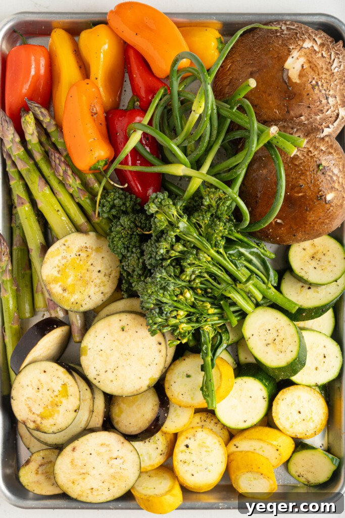 Effortless Grilled Vegetables: 3-Ingredient Marinade 7 Raw, sliced vegetables including zucchini, eggplant, and peppers, seasoned with salt and pepper on a baking sheet, ready for the grill.