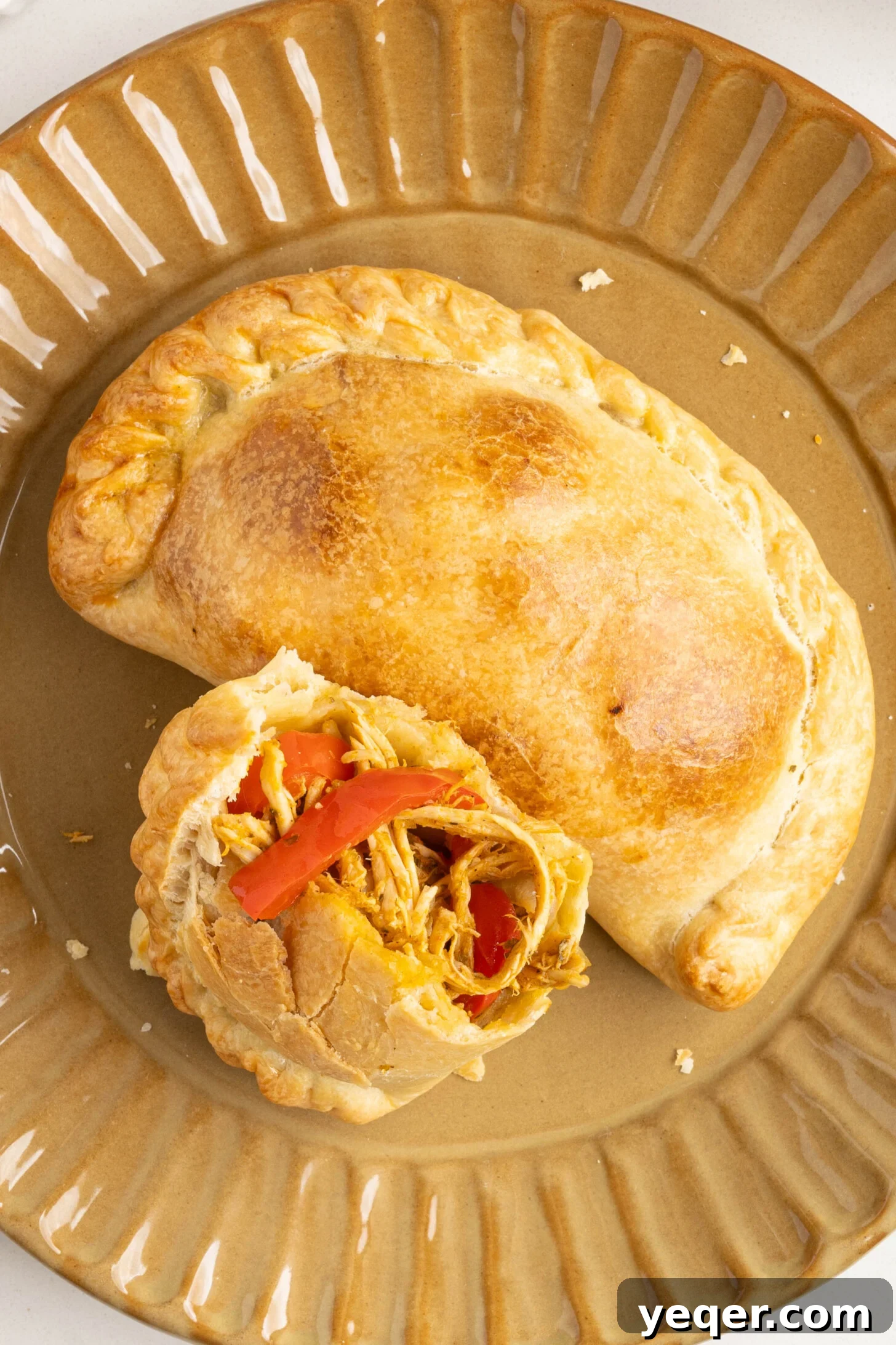 Homestyle Shredded Chicken Empanadas 13 A wide shot of a rustic table spread with multiple chicken empanadas, some in baskets and others on a cutting board, alongside fresh ingredients.