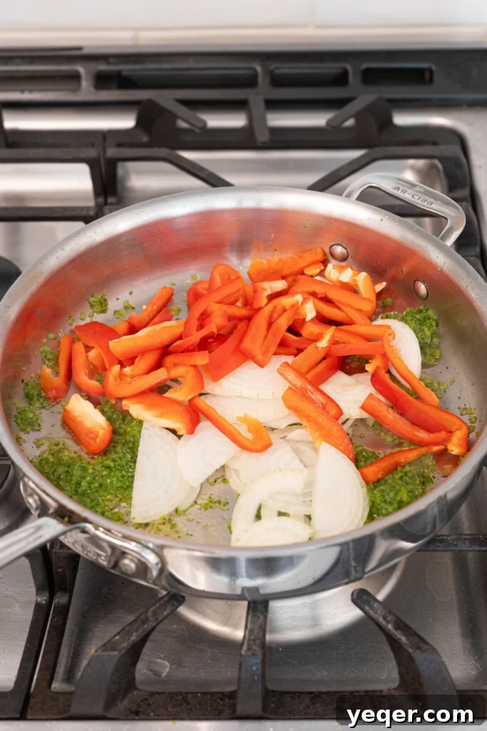 Homestyle Shredded Chicken Empanadas 5 A pot with sofrito, diced onion, and bell pepper simmering, releasing fragrant aromas.