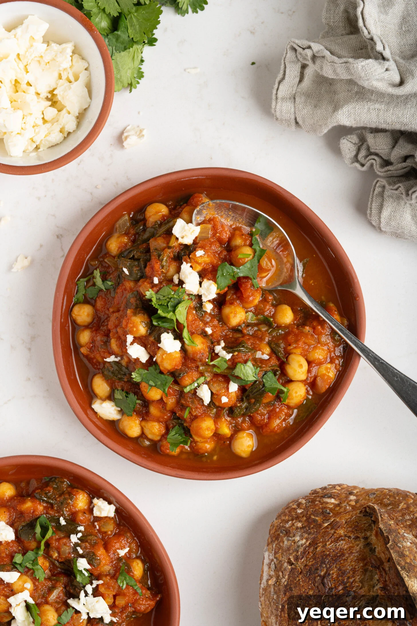 Hearty 30-Minute Moroccan Chickpea and Tomato Stew 10 Two bowls of flavorful Moroccan chickpea stew on a rustic wooden surface.