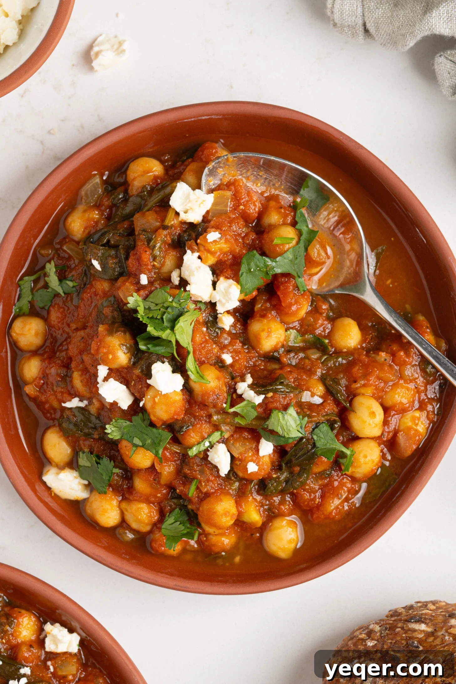 Hearty 30-Minute Moroccan Chickpea and Tomato Stew 11 Two cozy bowls of Moroccan spiced stewed chickpeas, garnished with fresh herbs and served with bread.