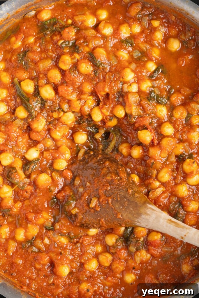 Hearty 30-Minute Moroccan Chickpea and Tomato Stew 7 A bubbling pot of Moroccan stewed chickpeas, garnished with fresh cilantro.