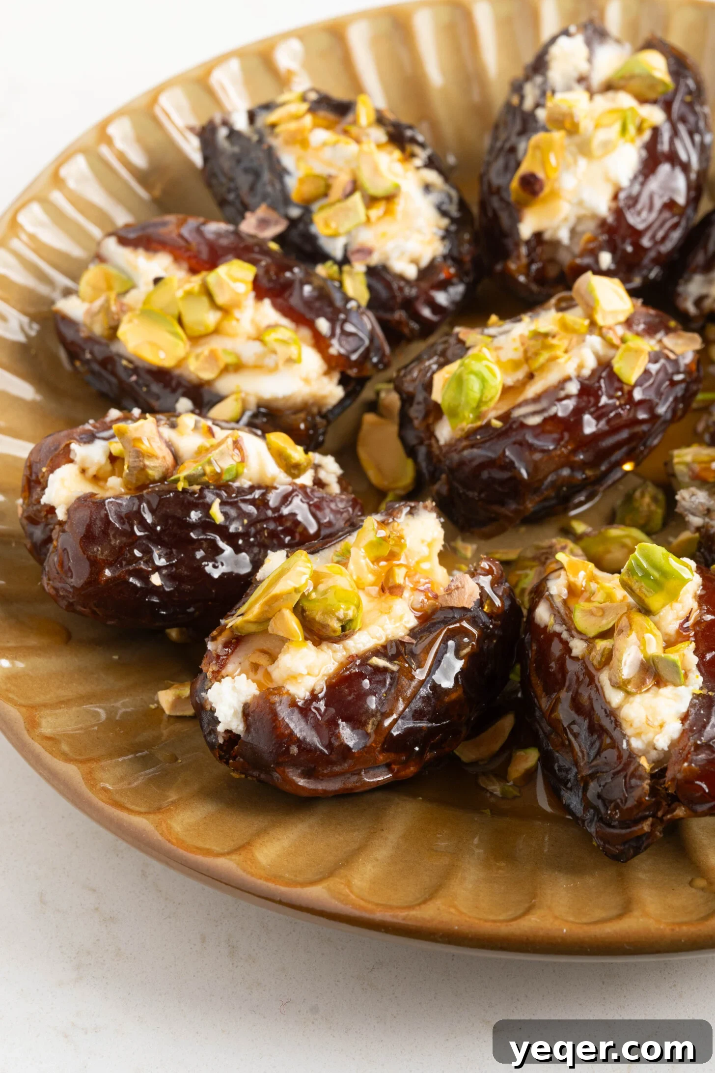 Gourmet Date Medallions: Goat Cheese and Pistachio Bliss 2 A beautifully presented plate of goat cheese stuffed dates, adorned with chopped pistachios and fresh herbs, ready to be served.