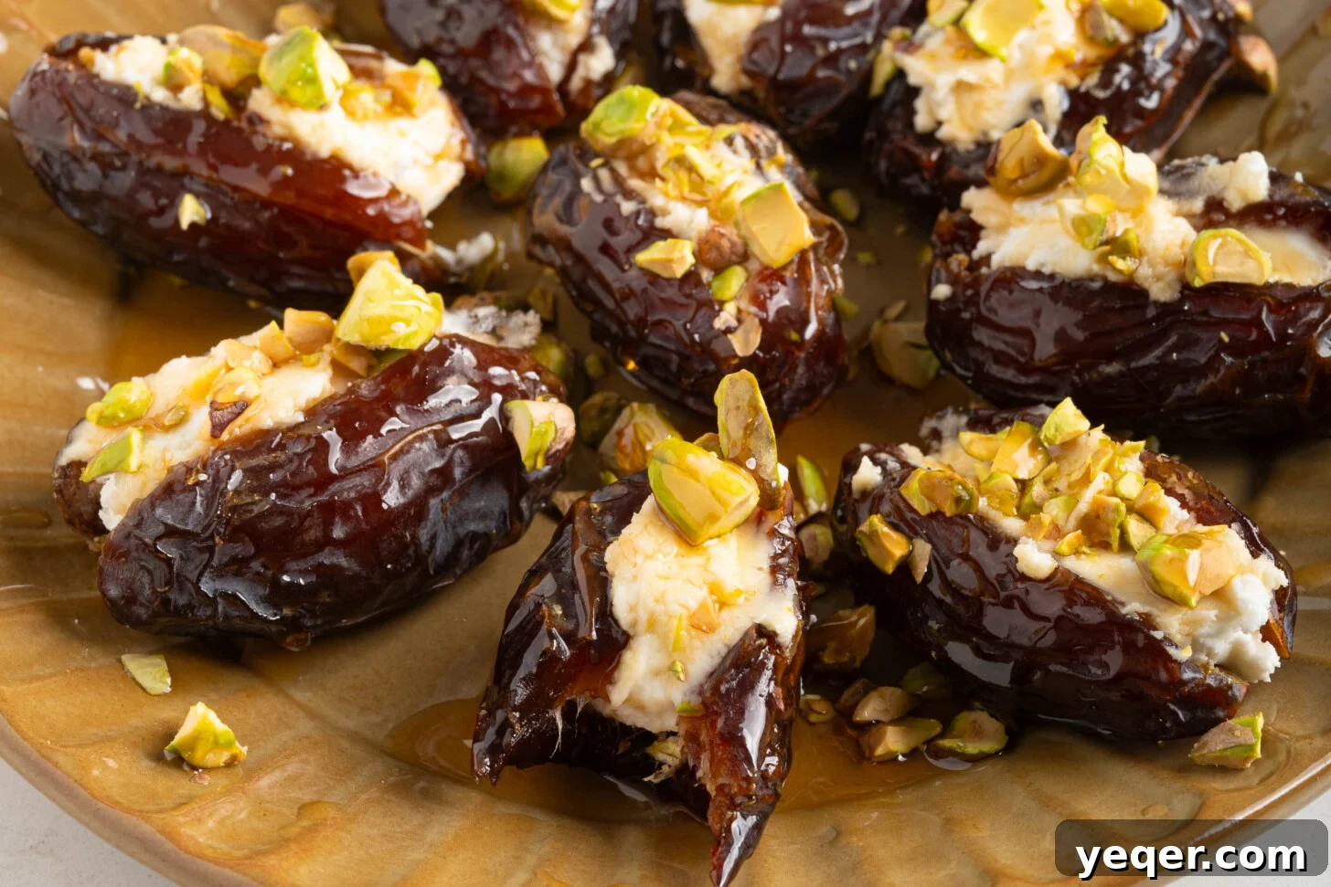 Gourmet Date Medallions: Goat Cheese and Pistachio Bliss 8 A close-up of a rustic plate filled with baked goat cheese stuffed dates, showing melted cheese and glistening honey.