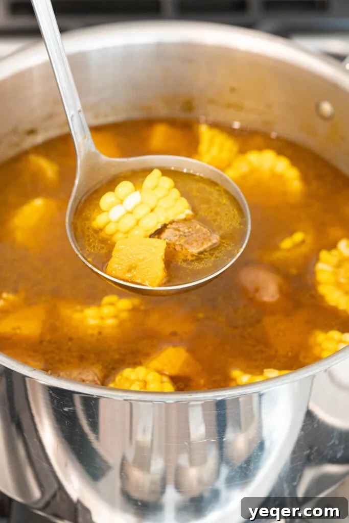 Rich Puerto Rican Sancocho Beef and Root Vegetable Stew 9 A vibrant bowl of Sancocho served with a side of fluffy white rice, garnished with fresh cilantro and a lime wedge, ready to be enjoyed.