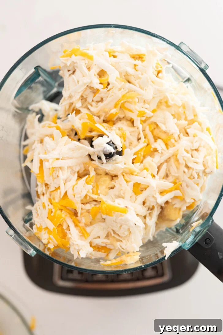 Puerto Rican Pasteles: Savory Meat-Stuffed Masa Delights 11 Grated masa ingredients being blended in a food processor, creating a smooth consistency.