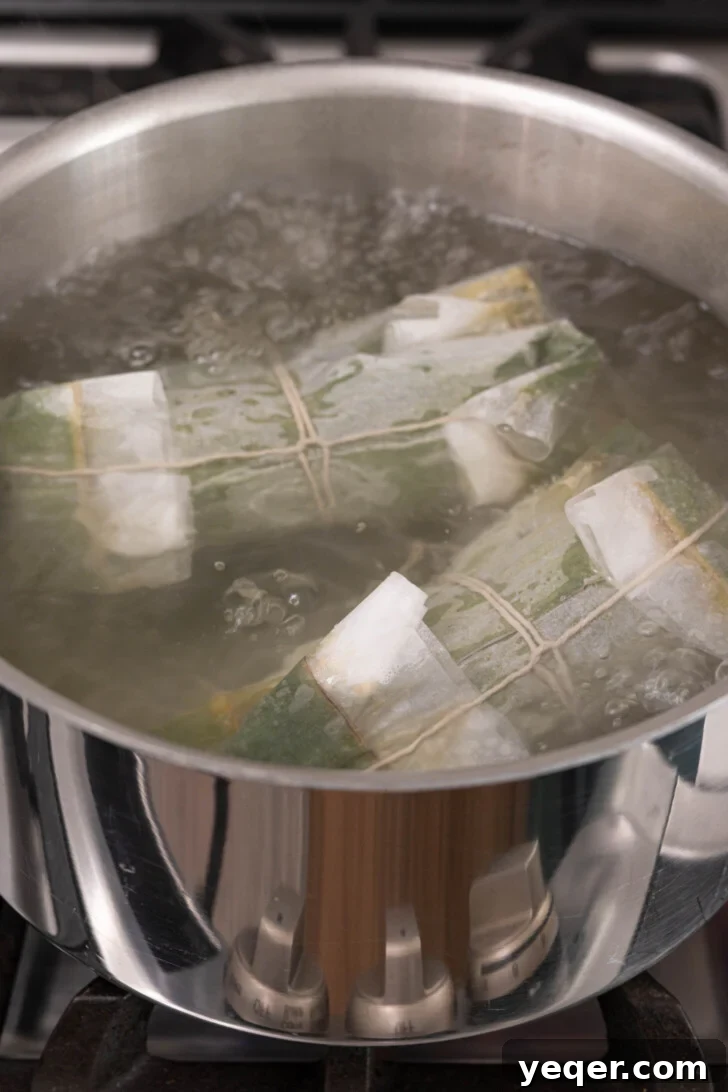 Puerto Rican Pasteles: Savory Meat-Stuffed Masa Delights 19 Pasteles boiling in a large pot of salted water, ready for cooking.