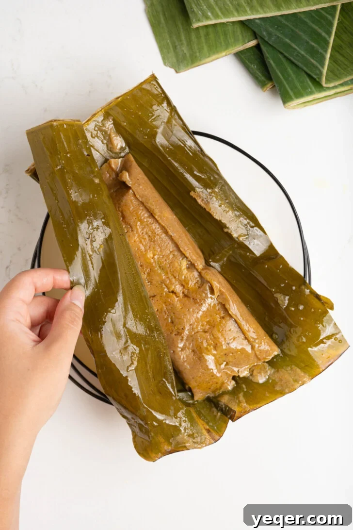 Puerto Rican Pasteles: Savory Meat-Stuffed Masa Delights 20 A cooked pastel, unwrapped and plated, ready to be garnished and served.