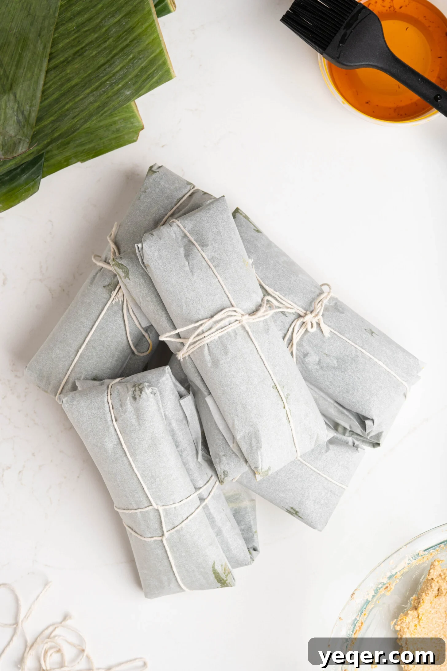 Puerto Rican Pasteles: Savory Meat-Stuffed Masa Delights 22 A collection of unwrapped Puerto Rican pasteles on a white kitchen counter, ready to be served.