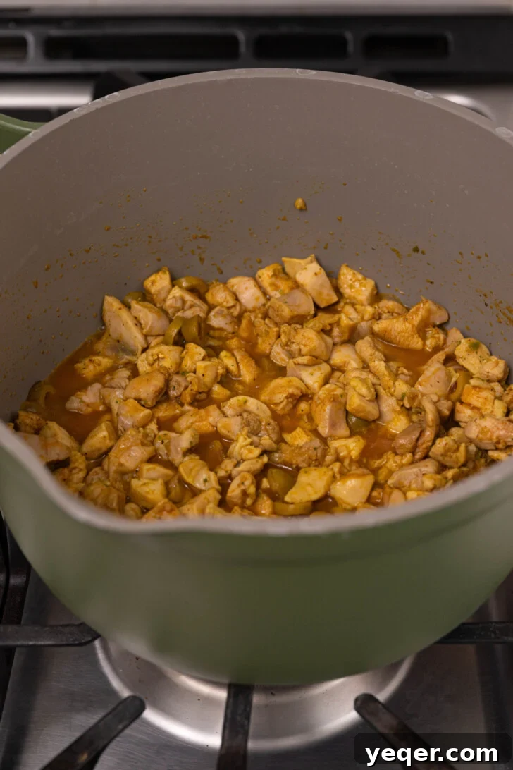 Puerto Rican Pasteles: Savory Meat-Stuffed Masa Delights 8 A pot of pasteles chicken filling, with some liquid reserved in a small bowl.