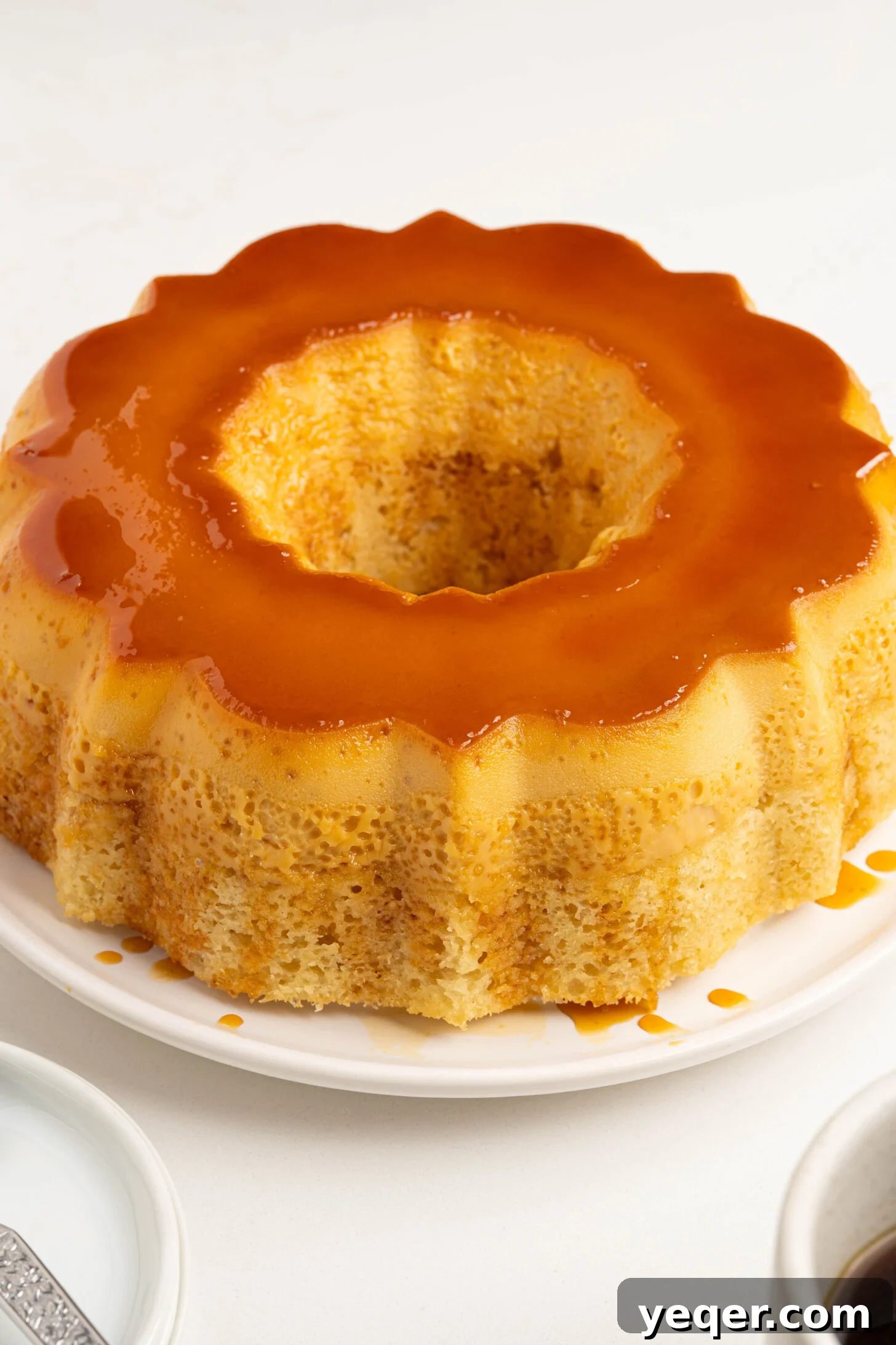Puerto Rican Flancocho: Vanilla Cake and Creamy Flan Fusion 2 A beautifully sliced piece of Flancocho on a white plate, showcasing its distinct caramel, flan, and vanilla cake layers.