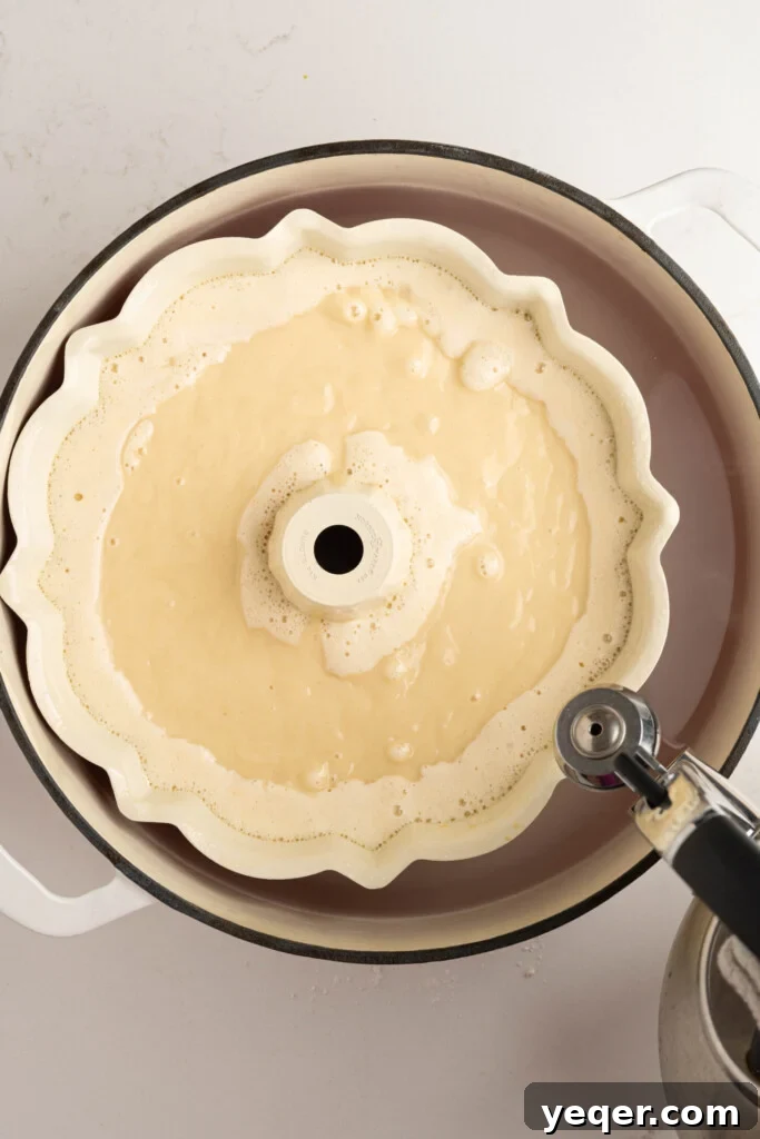 Puerto Rican Flancocho: Vanilla Cake and Creamy Flan Fusion 11 Hot water being poured into the larger baking dish surrounding the bundt pan for a water bath.