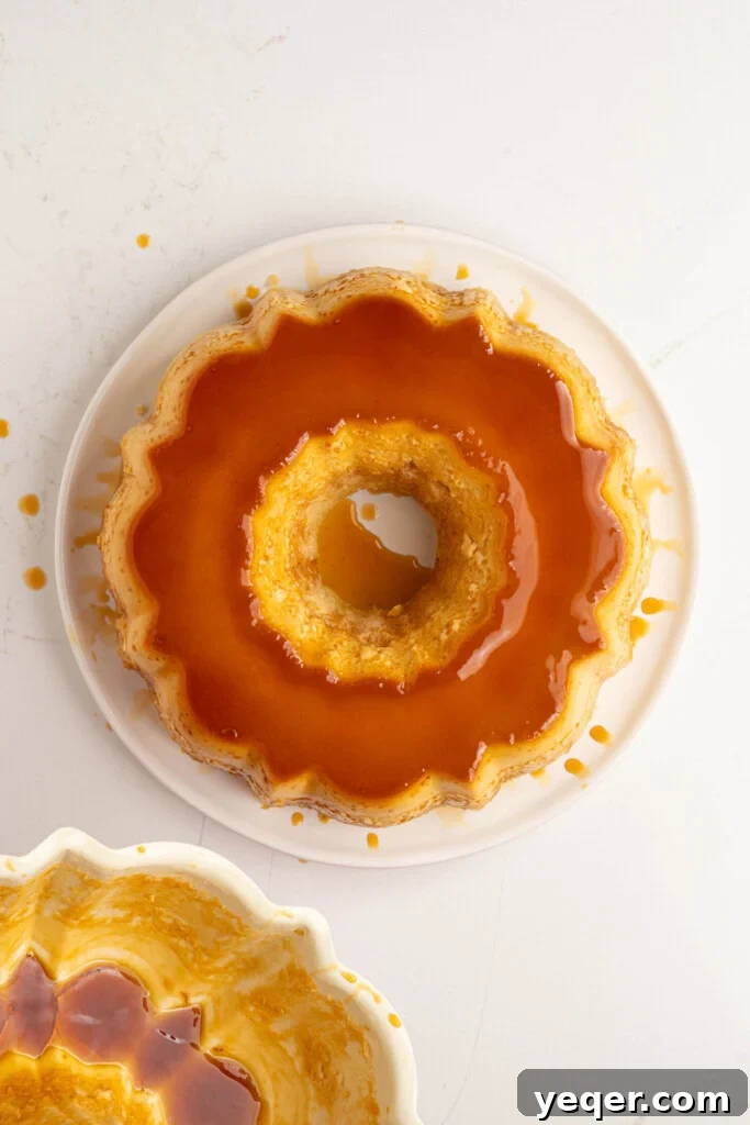 Puerto Rican Flancocho: Vanilla Cake and Creamy Flan Fusion 14 The fully inverted Flancocho on a white plate, ready to be served with caramel sauce drizzled over the top.