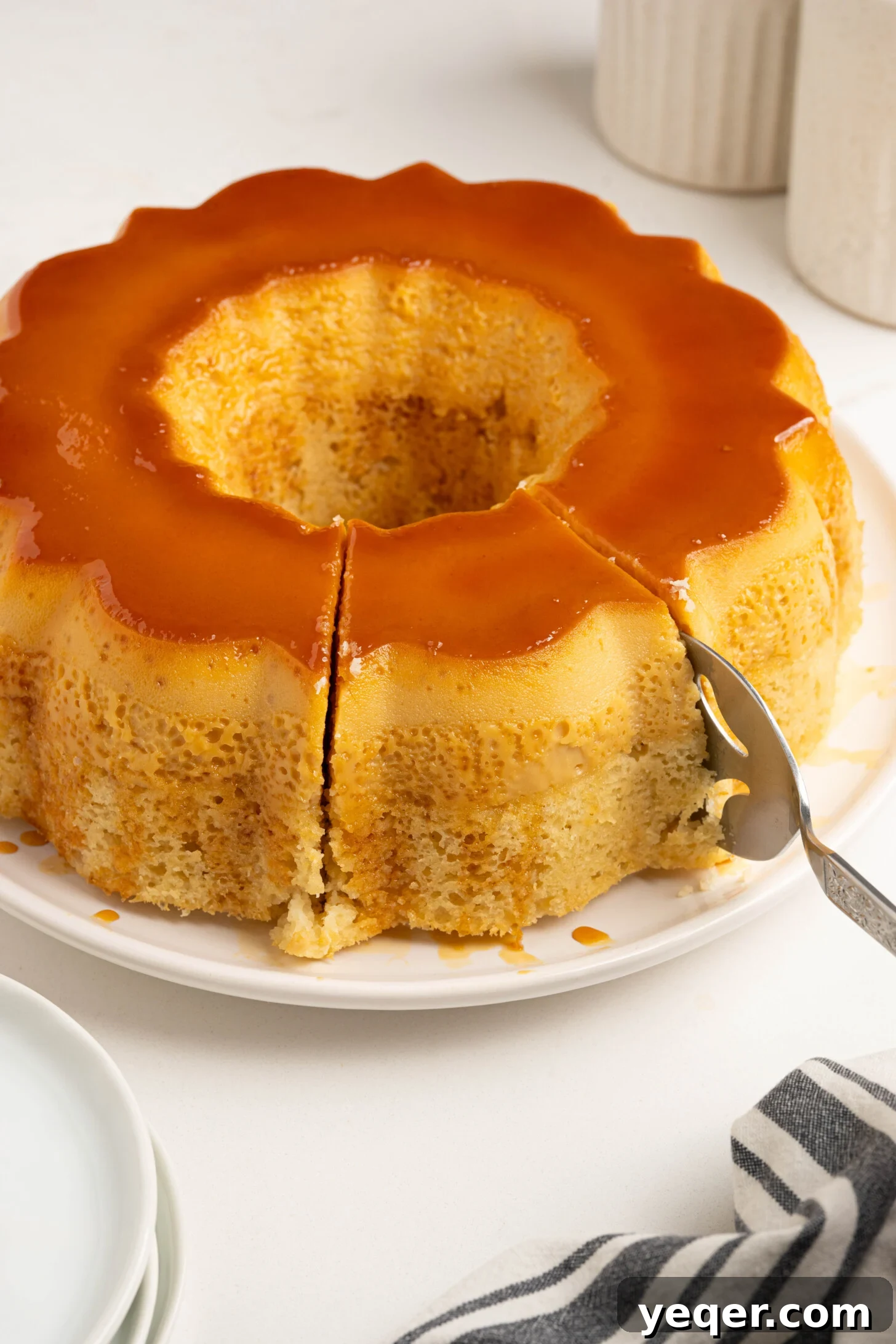Puerto Rican Flancocho: Vanilla Cake and Creamy Flan Fusion 16 A slice of Flancocho being gently cut from the whole cake, ready to be served.