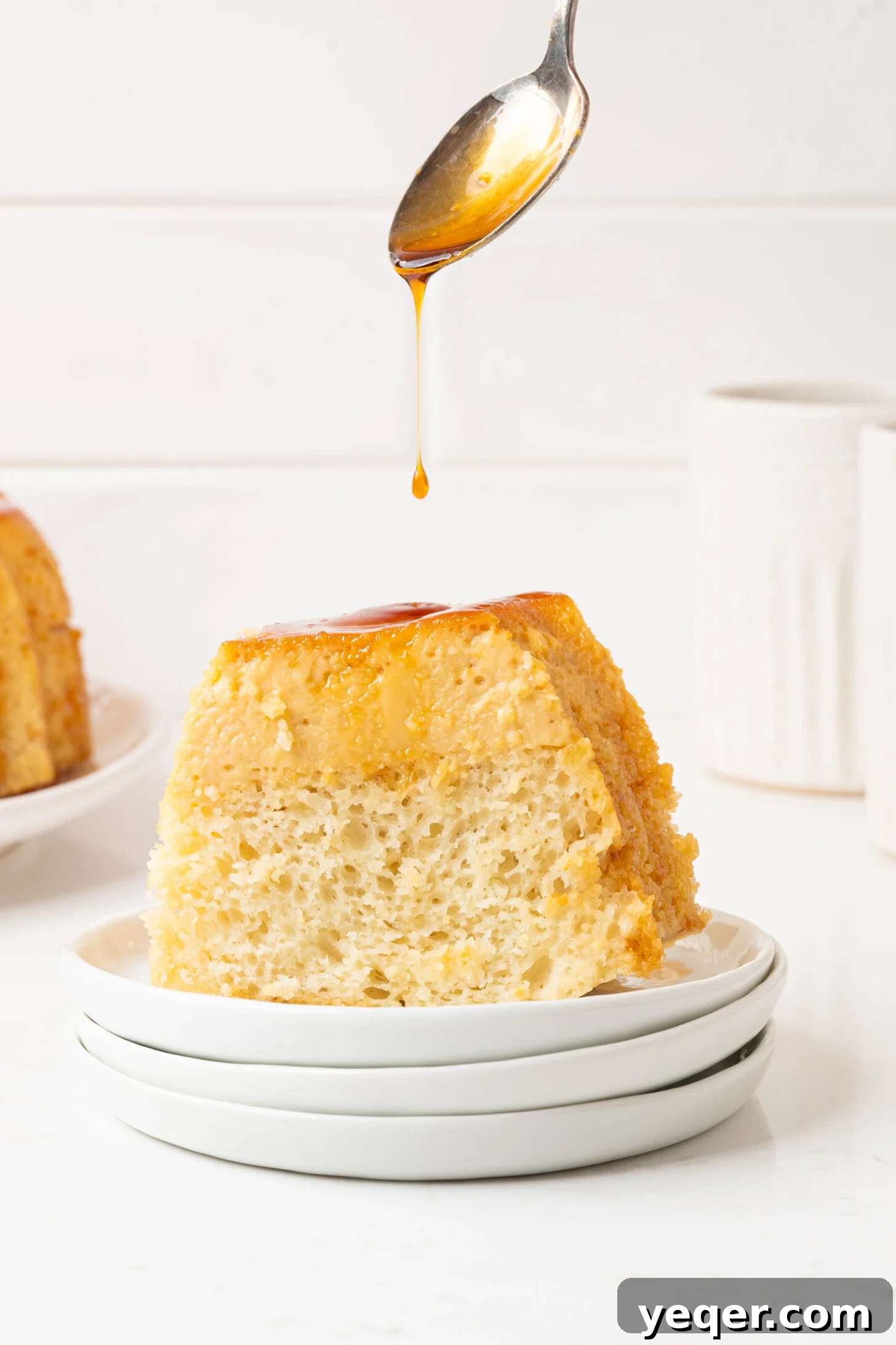 Puerto Rican Flancocho: Vanilla Cake and Creamy Flan Fusion 3 A close-up of a single slice of Flancocho on a white plate, highlighting the distinct caramel, flan, and vanilla cake layers.