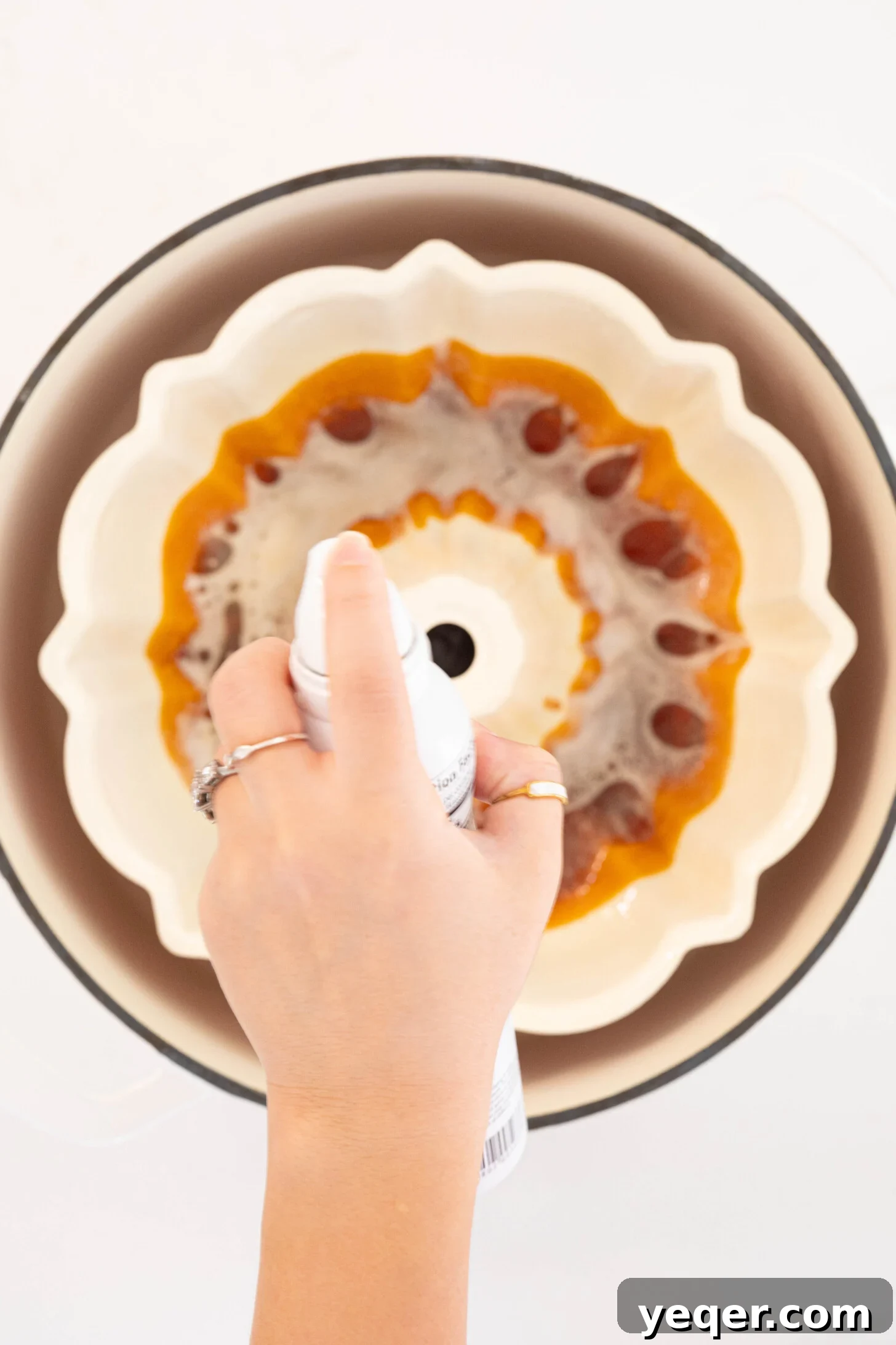 Puerto Rican Flancocho: Vanilla Cake and Creamy Flan Fusion 7 A bundt pan being generously coated with nonstick spray to prevent sticking.