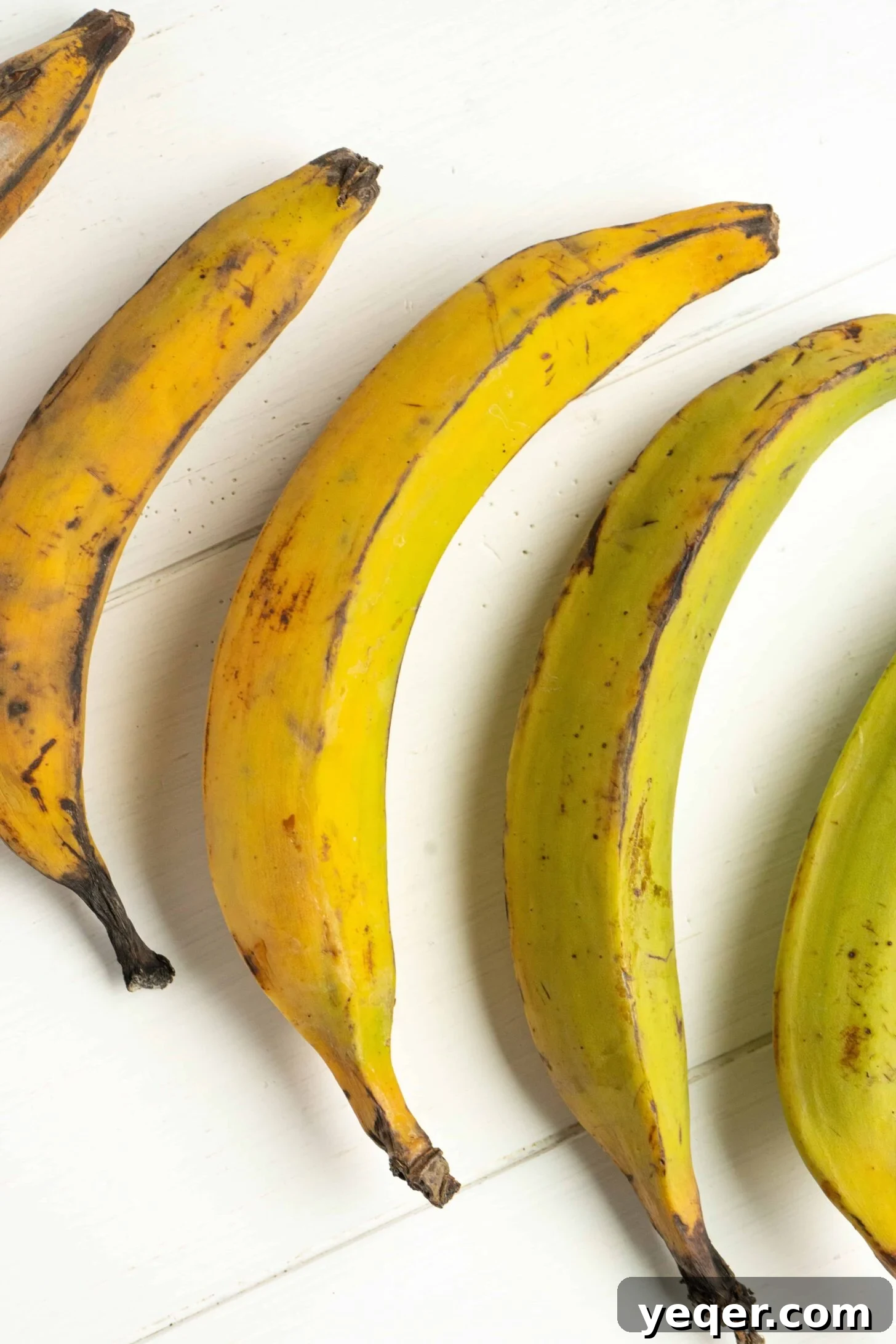 Master the Art of Peeling Any Plantain 2 A vibrant bunch of fresh plantains, showcasing their distinct green and yellow hues.