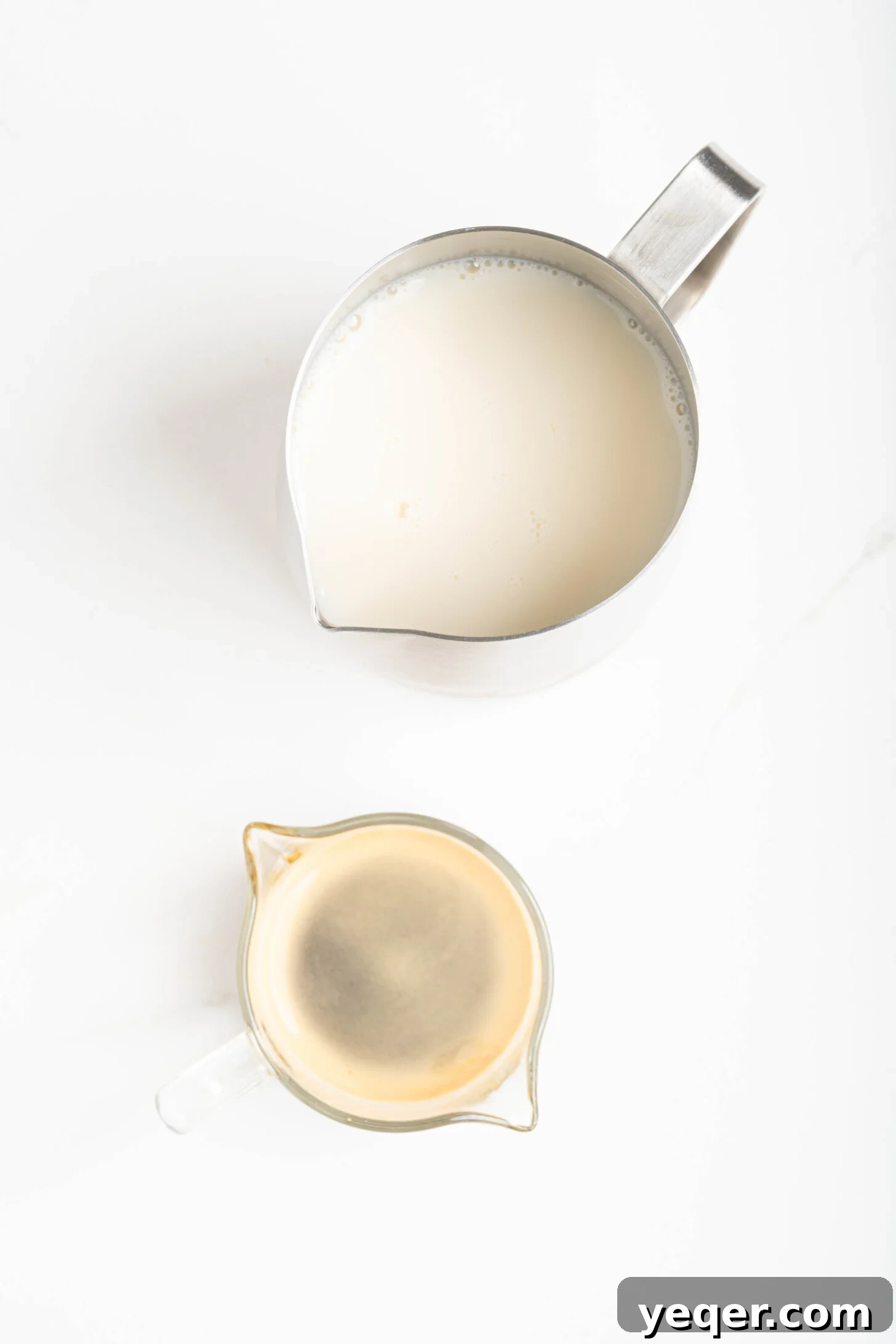 Your 10-Minute Cortado Perfect 1:1 Espresso and Steamed Milk 3 A shot of rich, dark espresso being poured into a small glass alongside a separate pitcher of perfectly steamed microfoamed milk, ready to be combined into a Cortado.