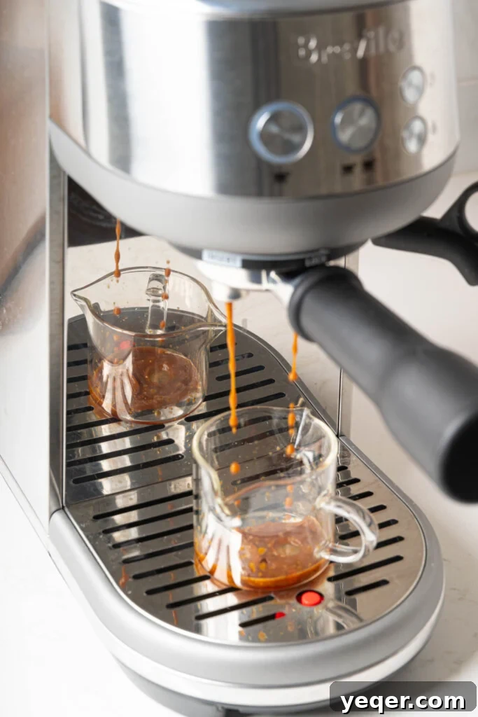 Your 10-Minute Cortado Perfect 1:1 Espresso and Steamed Milk 5 Freshly ground espresso brewing into a pre-warmed clear glass, with a rich crema forming on top.