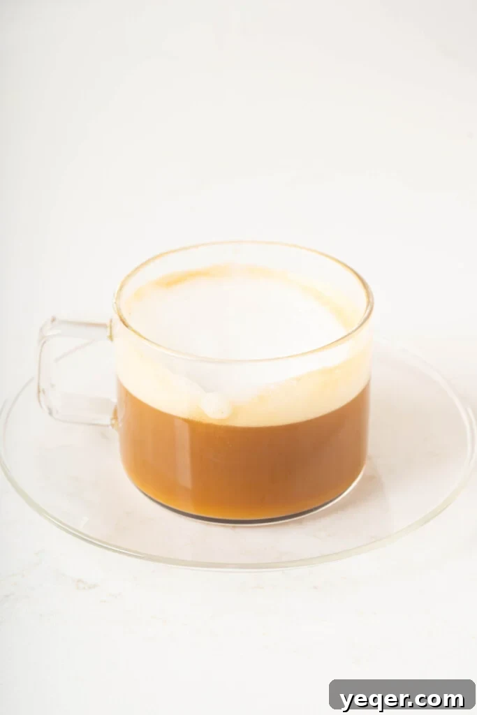 Your 10-Minute Cortado Perfect 1:1 Espresso and Steamed Milk 8 A perfectly made Cortado served in a small clear glass, ready to be enjoyed.
