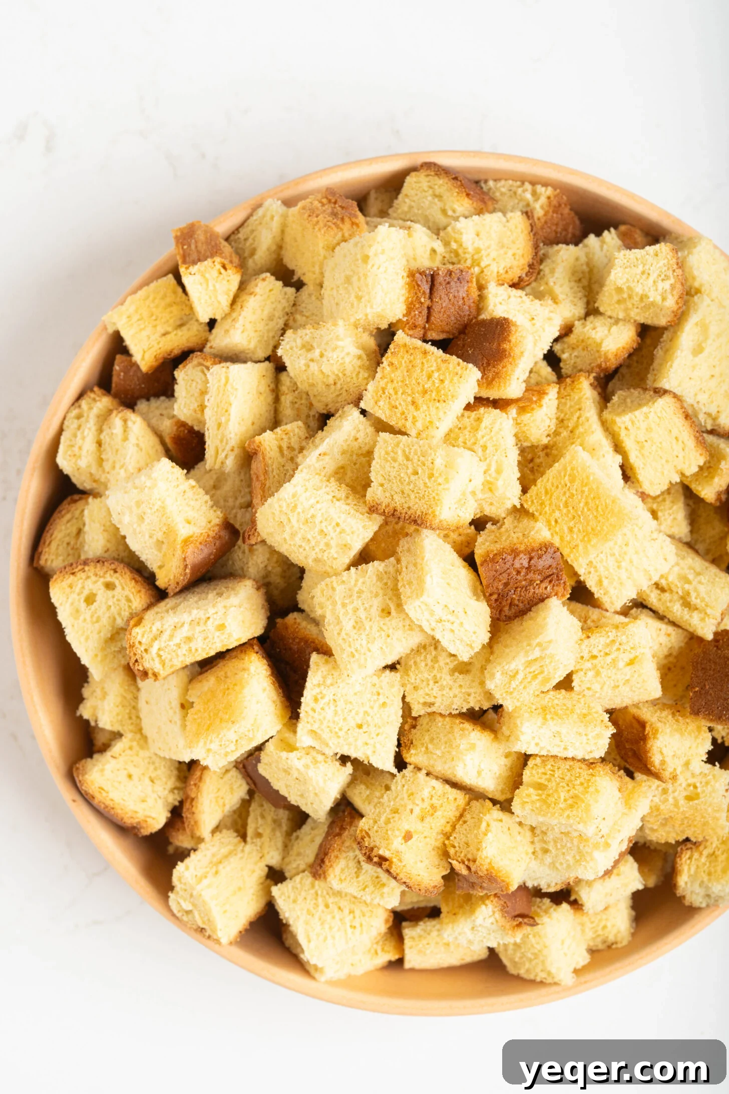 Puerto Rican Baked Bread Pudding 8 Small cubes of day-old bread neatly arranged in a large mixing bowl, ready to be soaked in the budin batter.