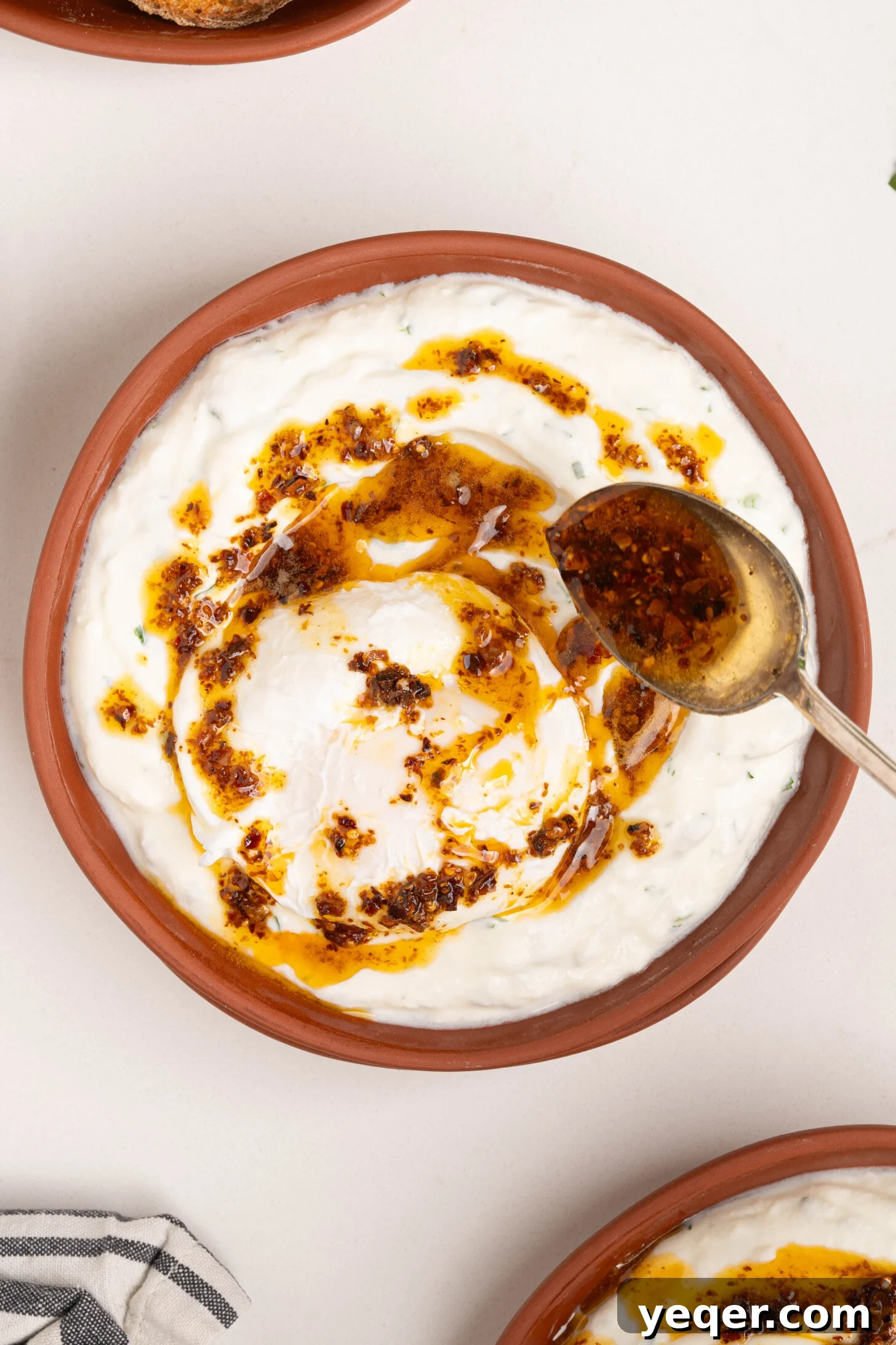 30-Minute Cilbir Turkish Eggs with Creamy Yogurt 7 Aleppo pepper butter being generously drizzled over a perfectly poached egg and garlic yogurt.