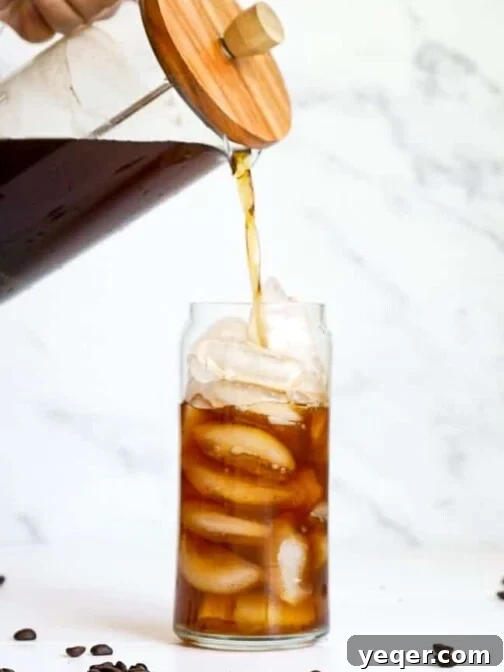 A French press pouring Overnight Cold Brew Coffee.
