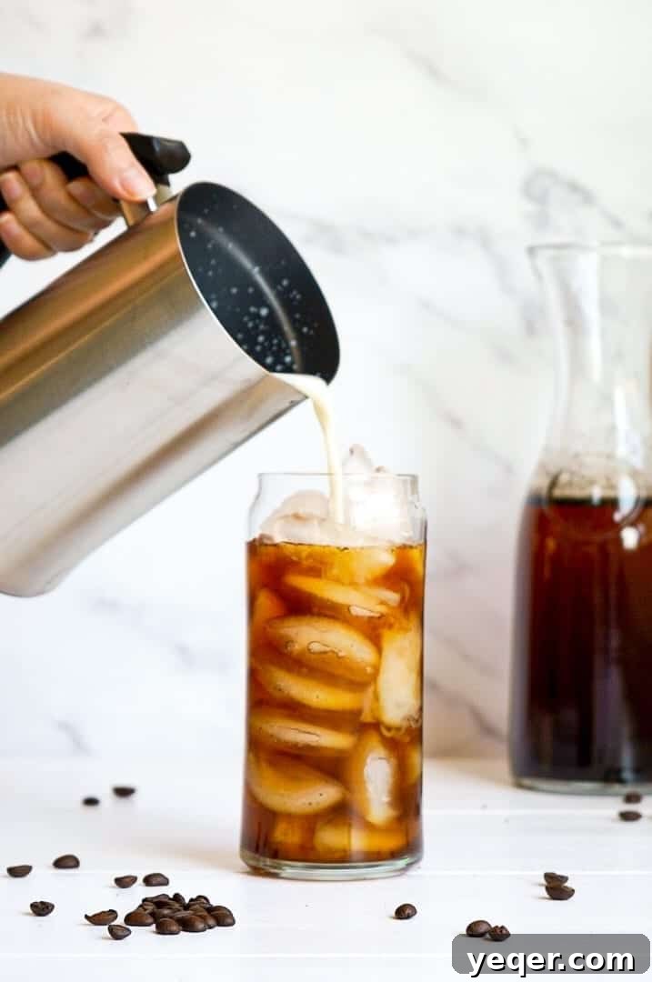 Smooth Cold Brew Overnight Delight 6 A French press pouring rich Overnight Cold Brew Coffee into a serving glass, highlighting its inviting color.