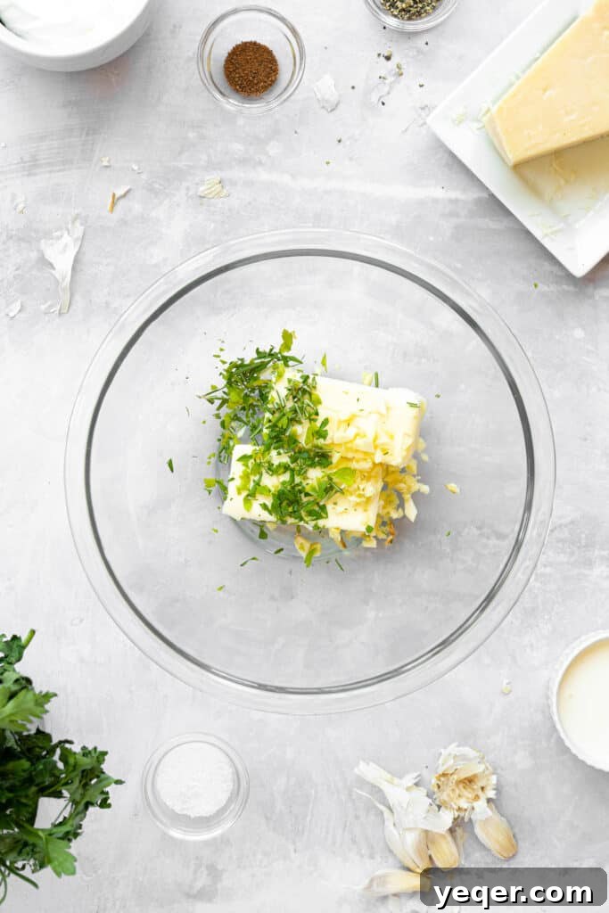 A glass bowl of butter with garlic and herbs.