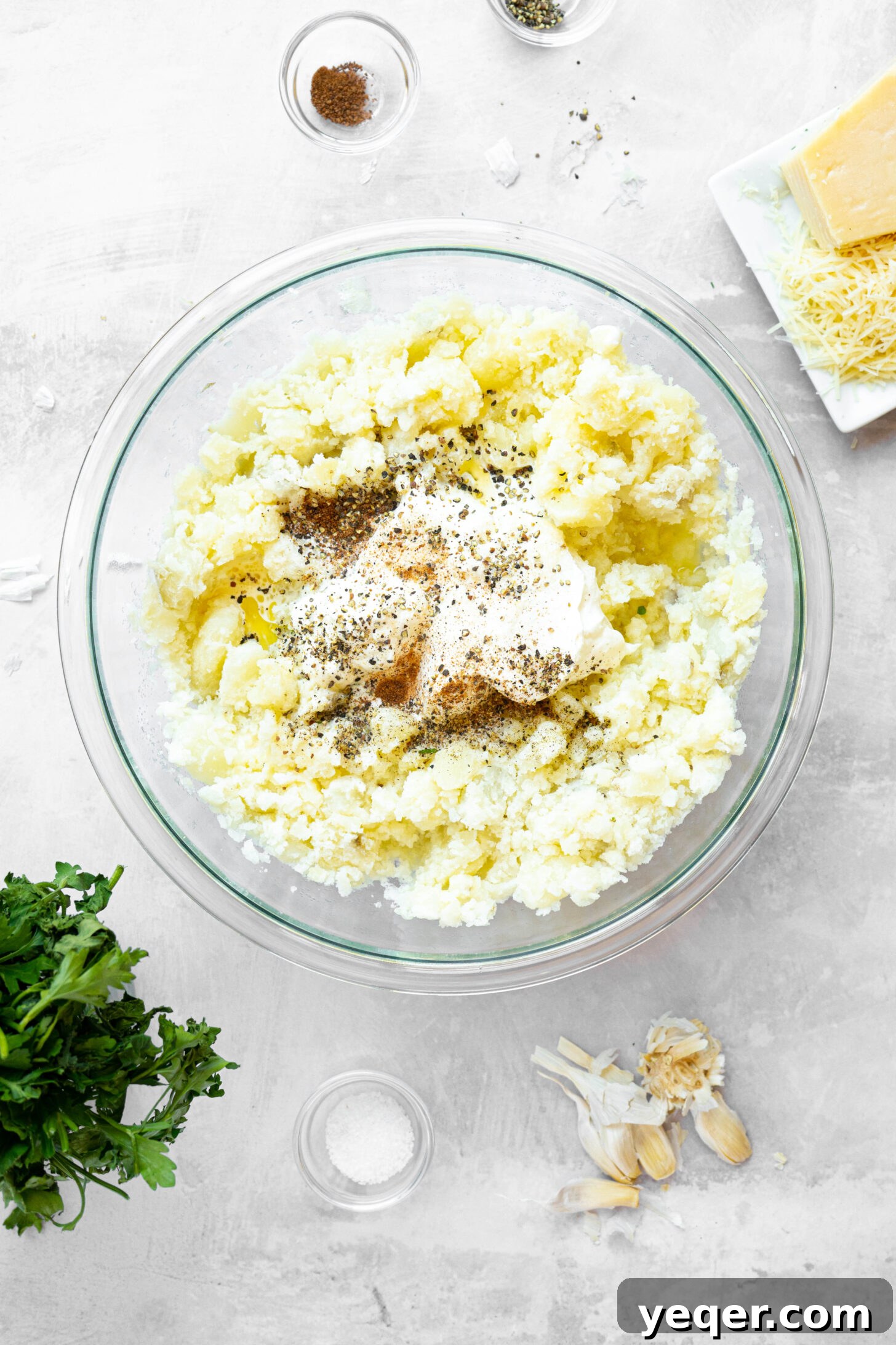 A bowl of mashed potatoes with spices and sour cream.
