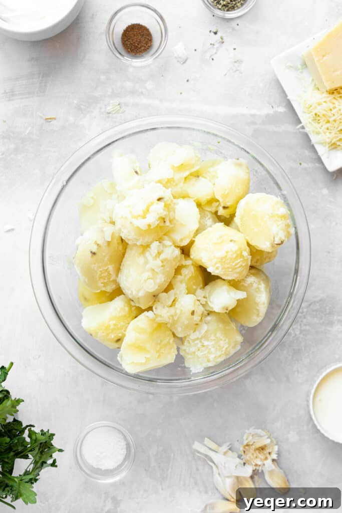 A glass bowl full of peeled and boiled potatoes.