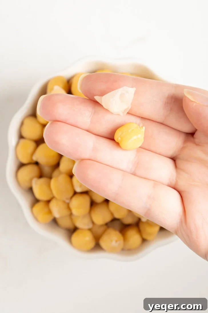 The Foolproof Soak and Boil Method for Perfect Dried Chickpeas 7 a hand holding a peeled chickpea