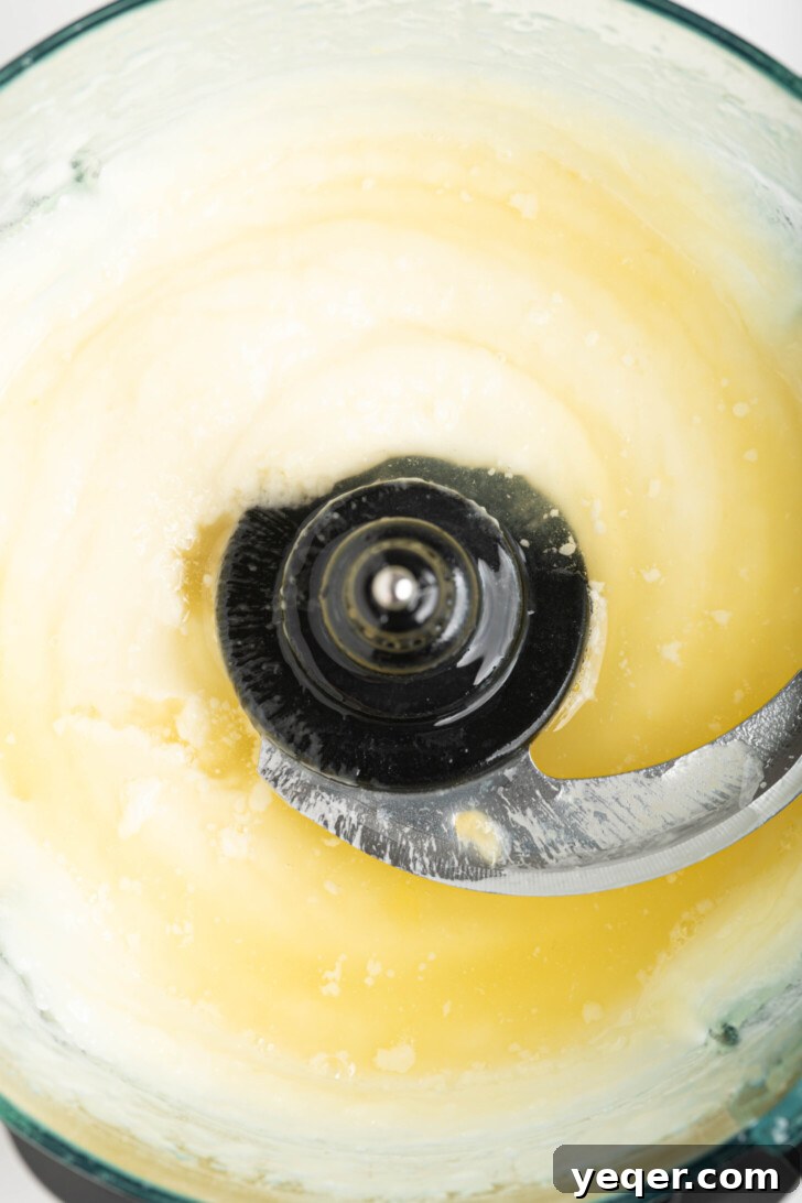 Fluffy 5-Ingredient Garlic Toum 6 a food processor with garlic sauce and lemon juice