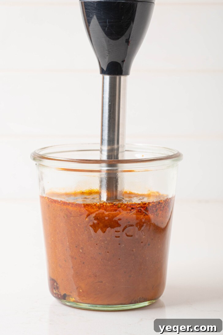 Effortless Chipotle Vinaigrette 6 An immersion blender actively blending the ingredients to make a smooth vinaigrette.