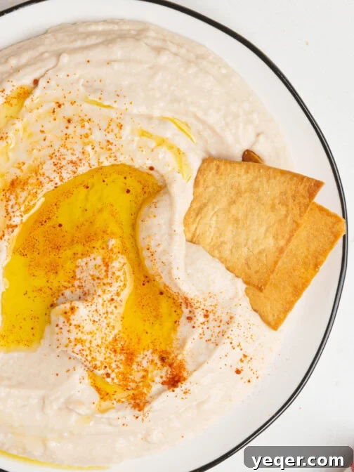 A plate of White Bean Hummus, garnished with olive oil and paprika.