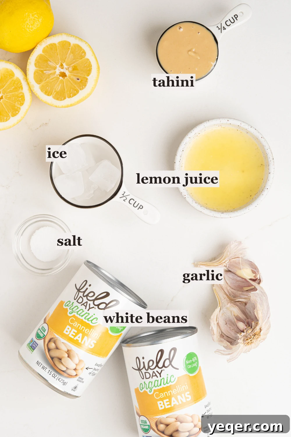 Bowls of fresh lemon juice, creamy tahini, and more ingredients ready for blending.