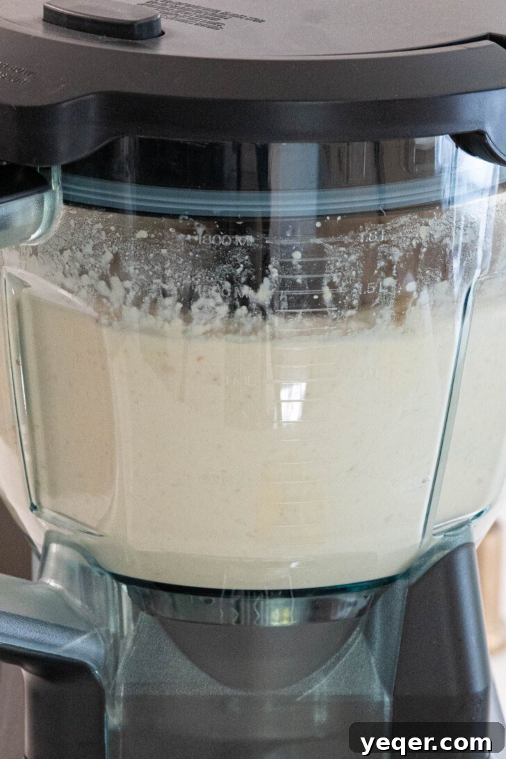 White bean hummus actively blending in a food processor.