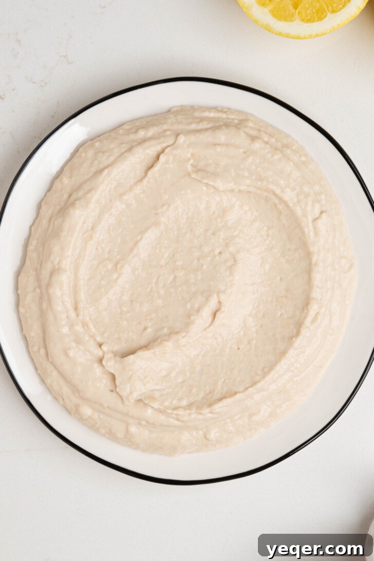 Freshly made white bean hummus spread on a plate.