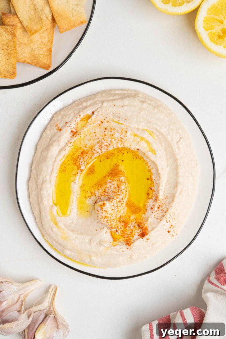 White bean hummus on a plate, garnished with olive oil and paprika.