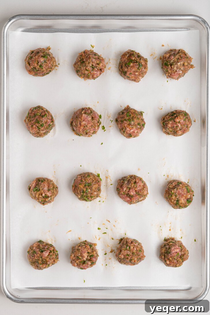 Moroccan Spiced Baked Lamb Meatballs 8 Lamb meatballs on a baking sheet.