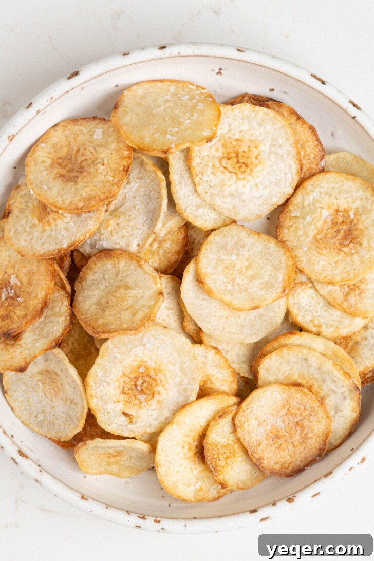 Crispy Taro Chips 30 Minutes Oven and Air Fryer 12 Baked taro chips turning golden brown and crispy in an oven or air fryer.