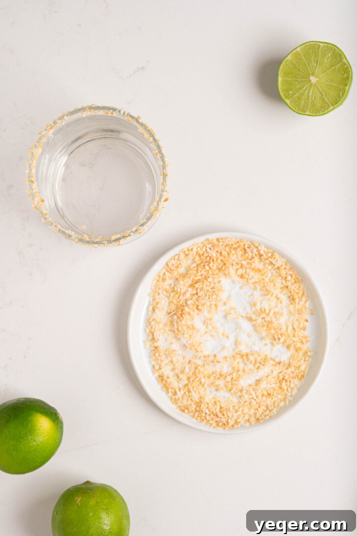Effortless Silky Coconut Margarita 4 A glass being prepared with a coconut rim on a counter.