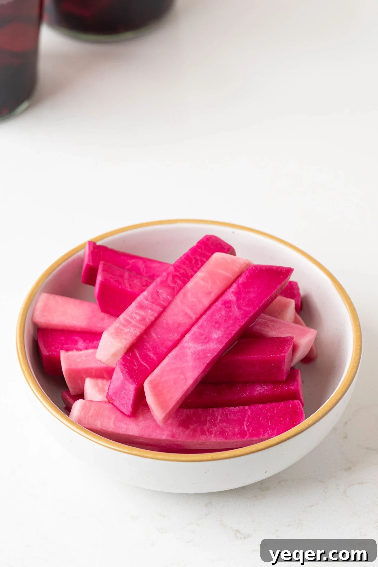 Easy 5-Ingredient Pink Pickled Turnips 3 A close-up shot of a bowl filled with crunchy, pink pickled turnips, highlighting their vibrant color and texture.
