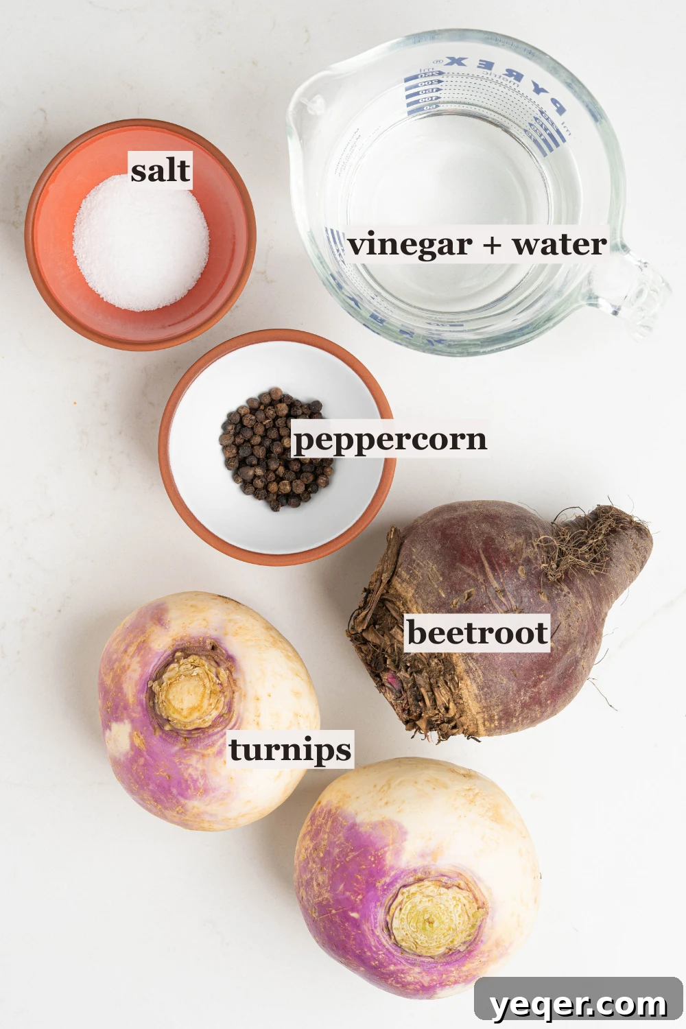 Easy 5-Ingredient Pink Pickled Turnips 4 An overhead shot showcasing bowls of fresh turnips, a small beet, salt, and black peppercorns, arranged for pickling.