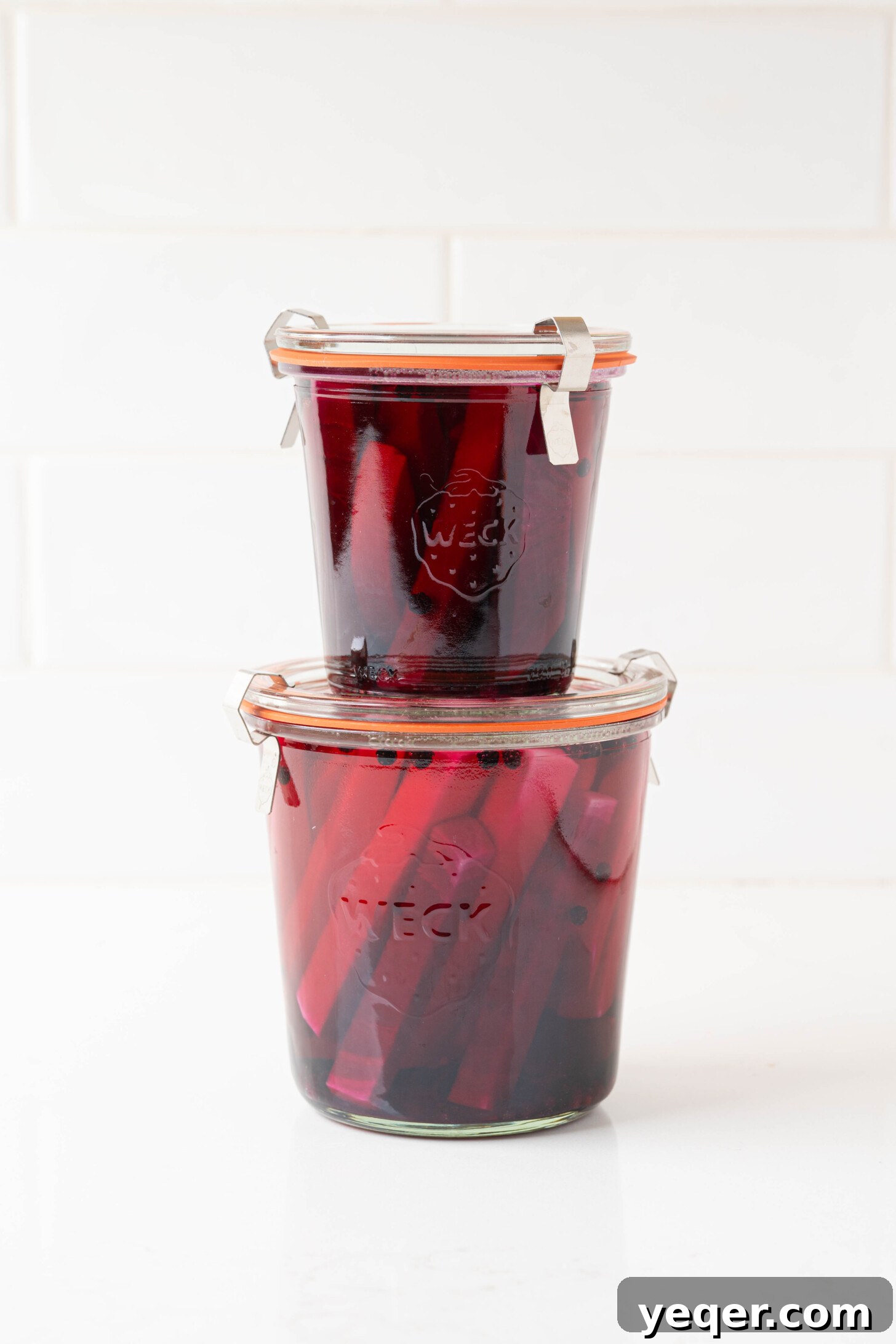 Easy 5-Ingredient Pink Pickled Turnips 10 Two glass jars filled with pink pickled turnips, showcasing the completed pickling process and vibrant color.