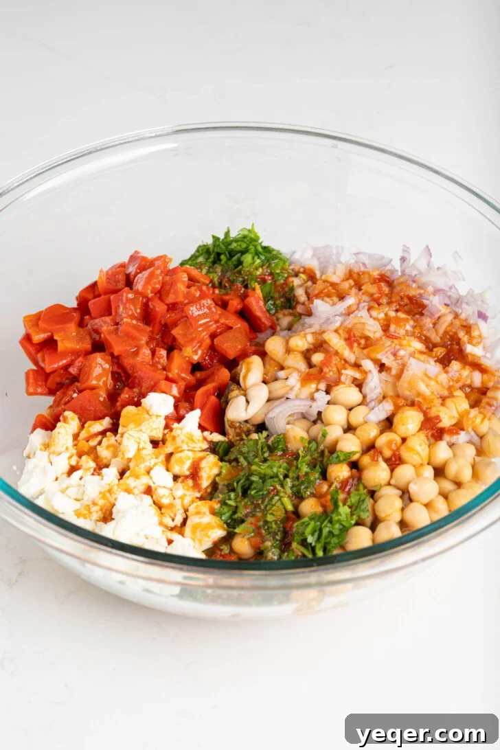 Golden Roast Chicken & Bean Feast 7 A large mixing bowl with the dressing at the bottom, topped with feta cheese, various beans, diced shallots, and herbs, awaiting a final toss.