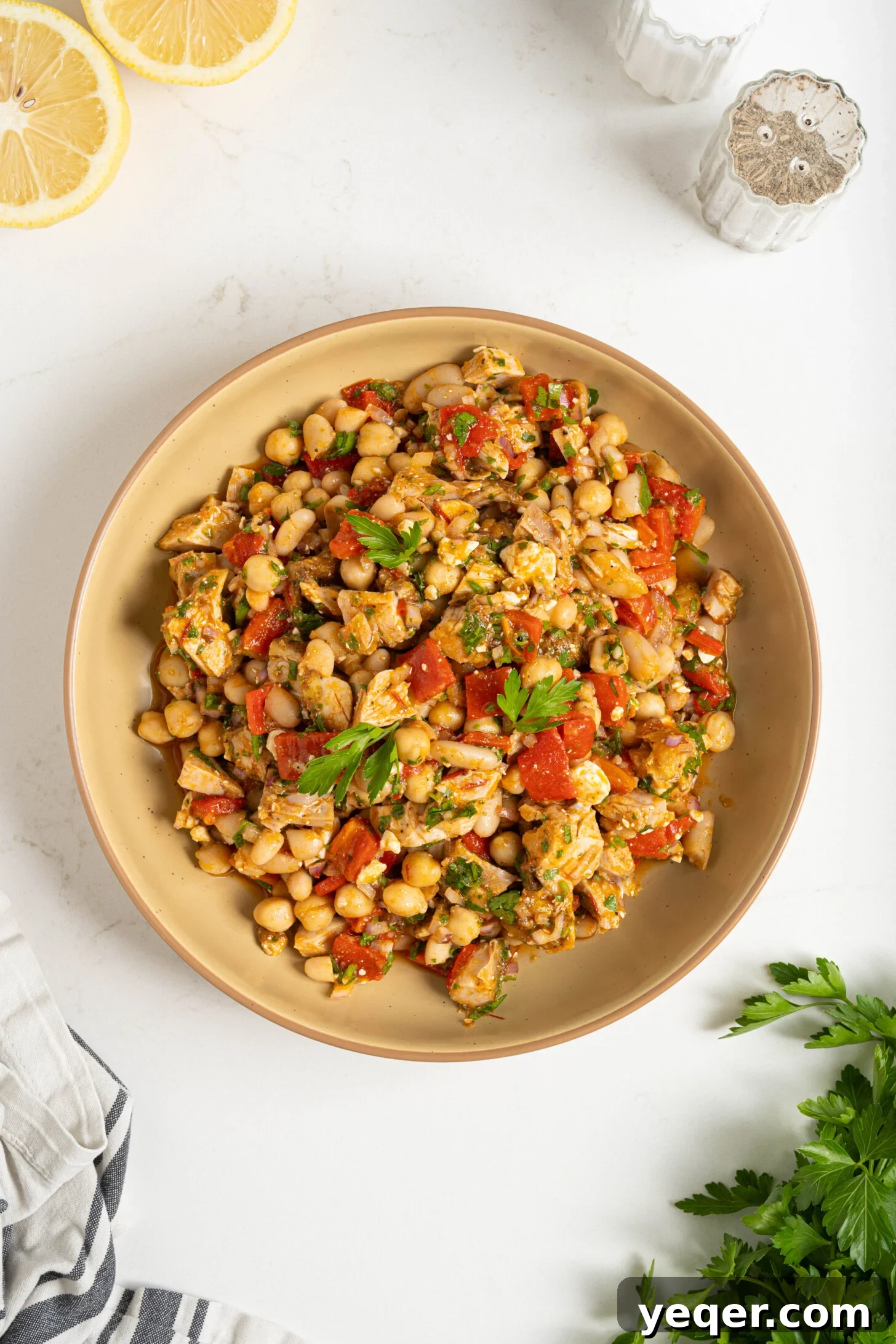 Golden Roast Chicken & Bean Feast 9 A generous serving of the Moroccan dense white bean salad, garnished with extra fresh herbs and a drizzle of dressing, emphasizing its richness.