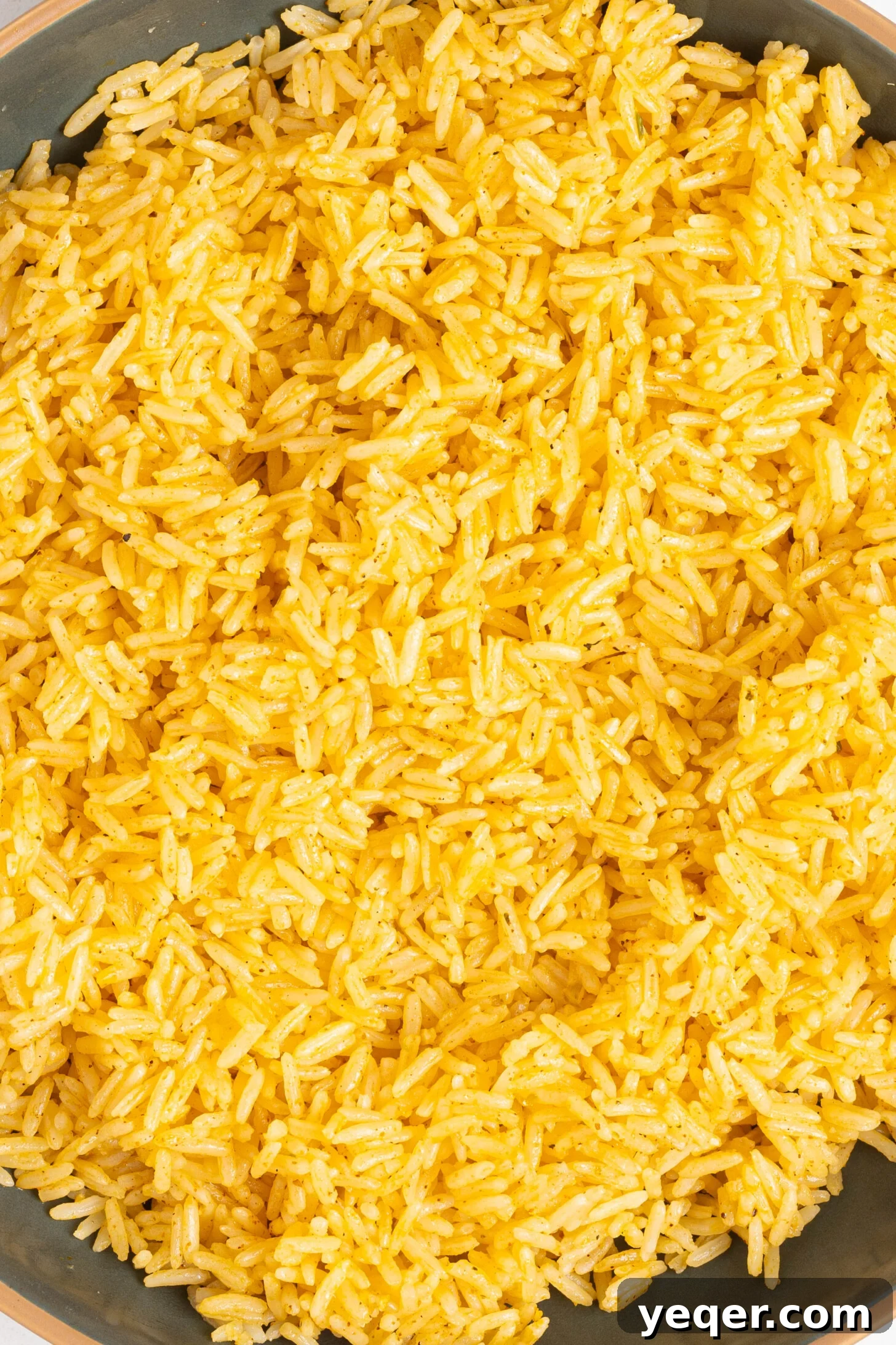 Fluffy 30-Minute Yellow Rice 3 Close-up shot of steaming Arroz Amarillo in a serving bowl, ready to be enjoyed.