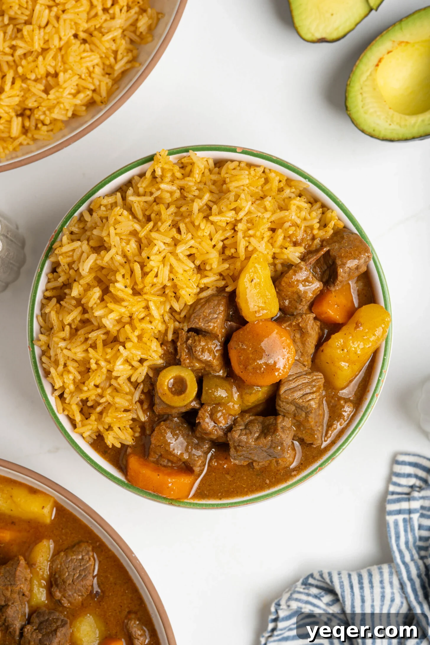 Fluffy 30-Minute Yellow Rice 10 A bowl of Puerto Rican beef stew (carne guisada) served alongside a generous portion of Arroz Amarillo.