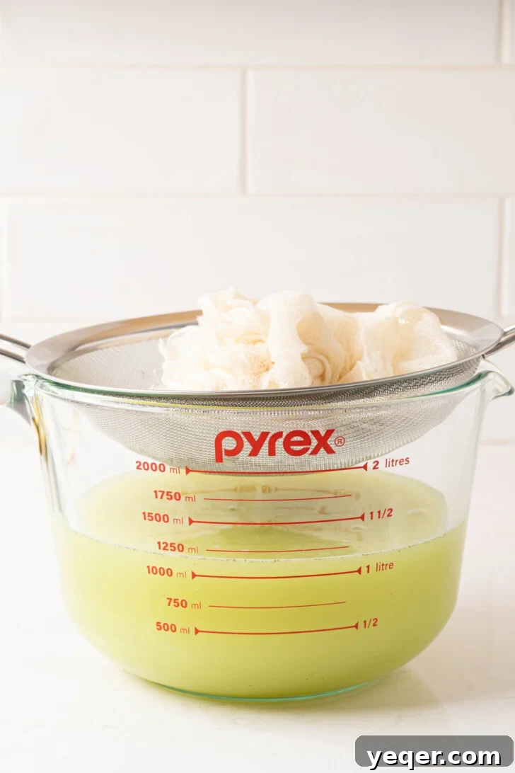 Mediterranean Breeze Mint Lemonade 7 Mint lemonade being strained through a cheesecloth into a pitcher.